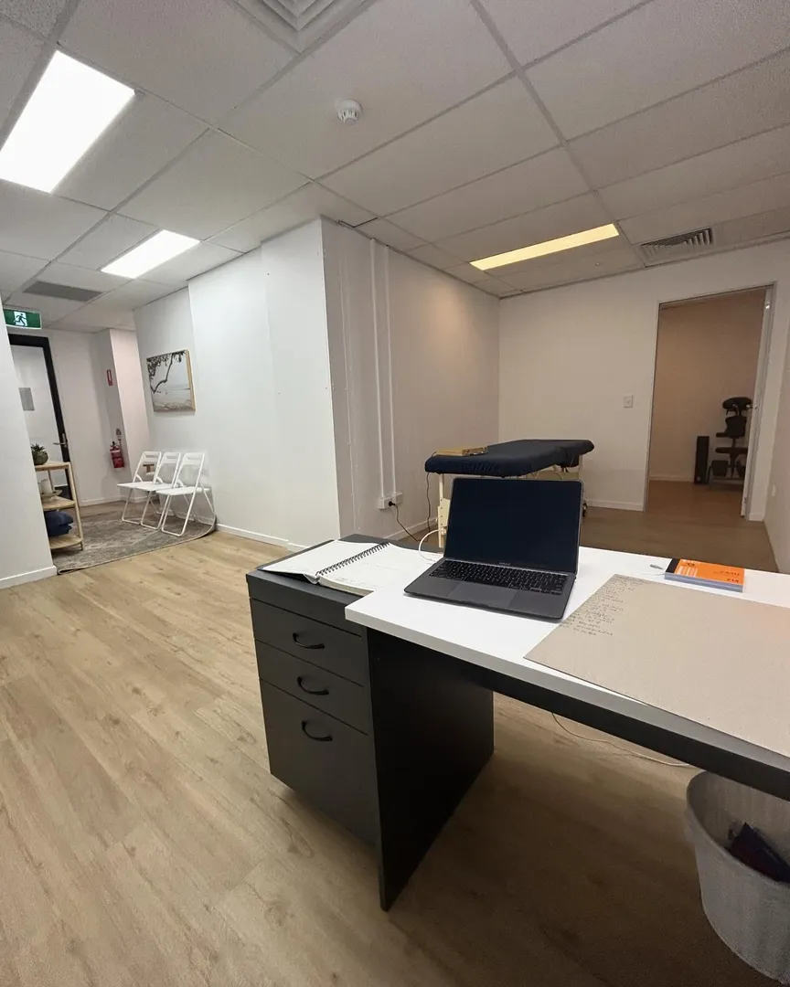 Modern office with desk and laptop.