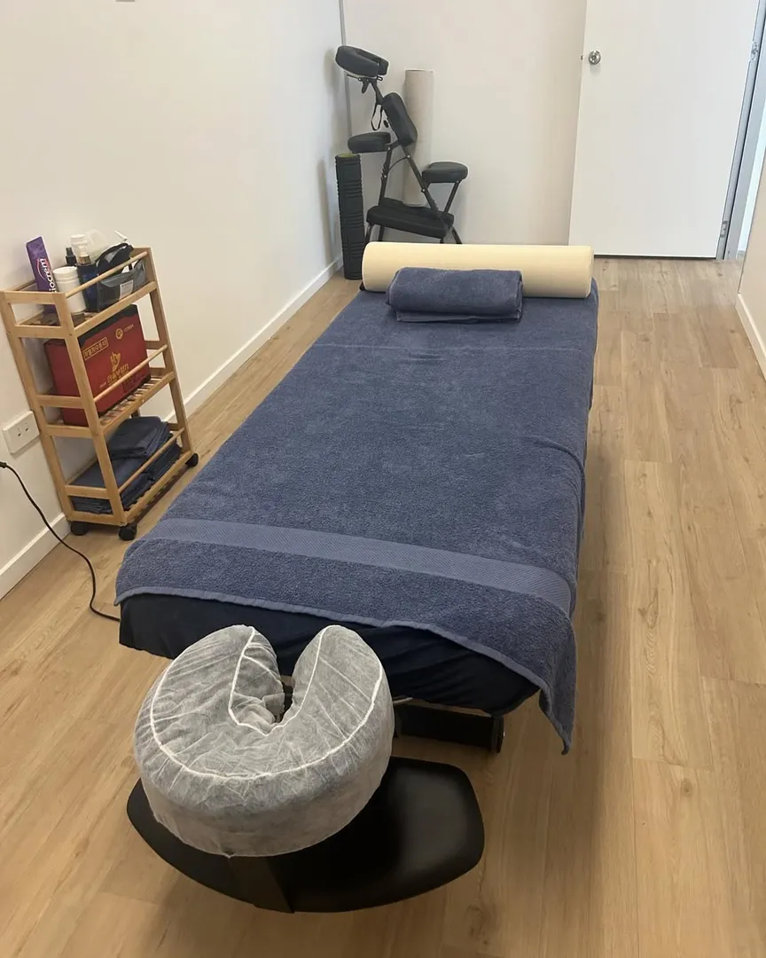 Massage room with table and chair setup.